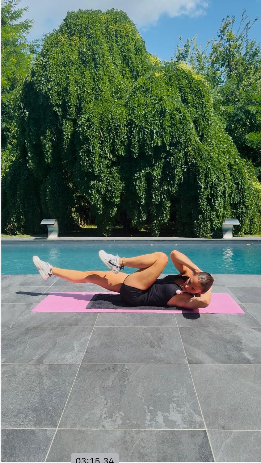 Sandy Longo en exercice d'abdominaux sur tapis pendant une séance Sanoafit